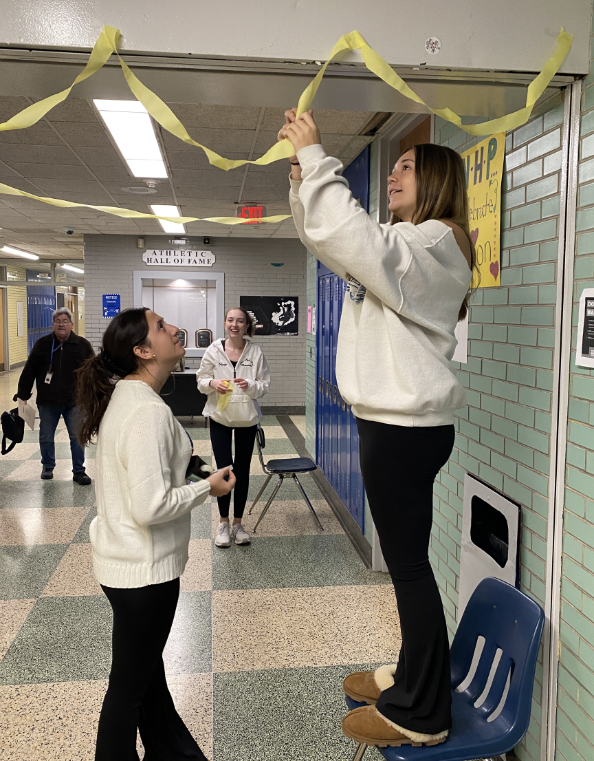 NHP Best Buddies Secretary Georgina Giannatsis decorates the special education hallway with yellow streamers, symbolizing the color of inclusion. 